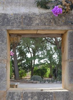 Stone Wall Opening with pink flower. Mallorca, Balearic islands, Spain.