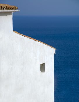 White building by clear blue Mediterranean sea, Mallorca, Balearic islands, Spain.