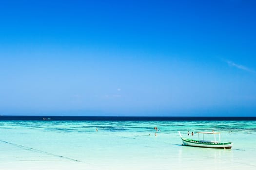 Beautiful small fishing wooden boat located in blue sea and sky