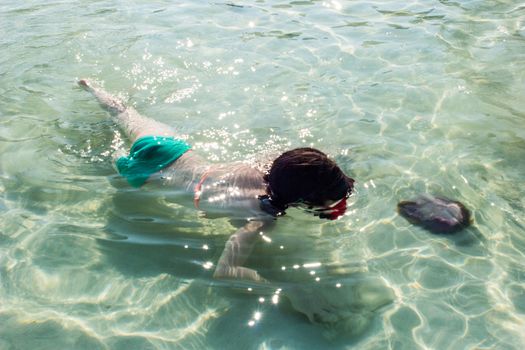 child swimming underwater in sea 