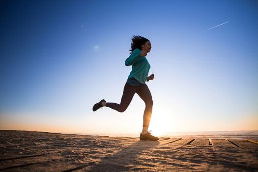 Young afro woman running on the beach