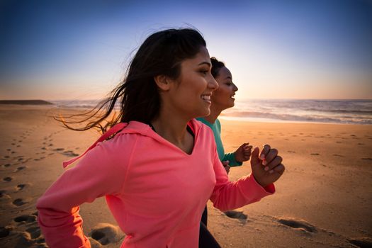 Couple of women running and walking on the beach