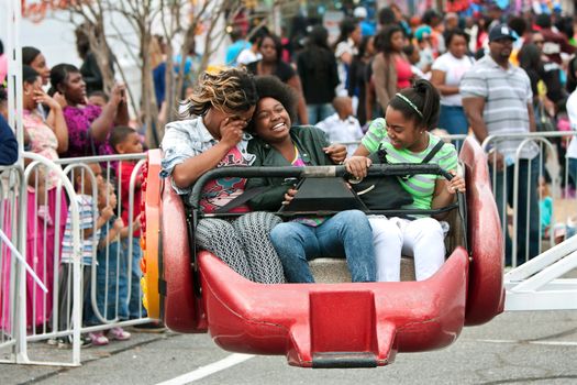 Atlanta, GA, USA - March 15, 2014:  Three women laugh while riding a fast-moving carnival ride at the annual Atlanta Fair. 