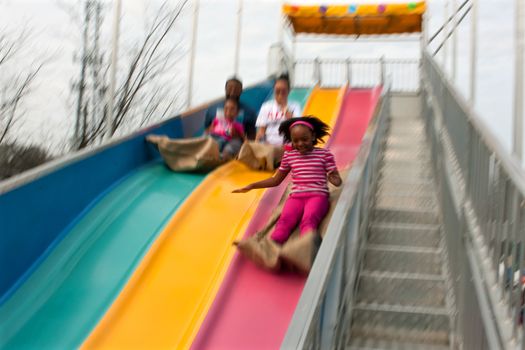 Atlanta, GA, USA - March 15, 2014:  Motion blur of a family sliding down the fun slide at the annual Atlanta Fair.