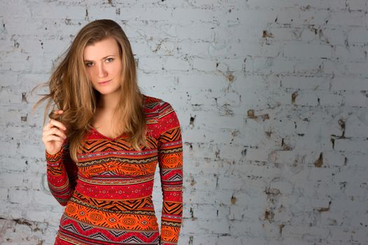 Girl in a blue shirt against a background of  brick wall