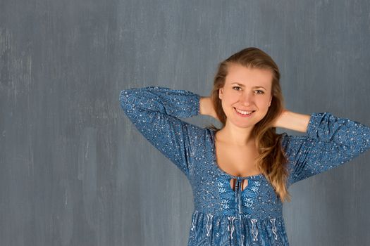 Girl in blue dress on wall background