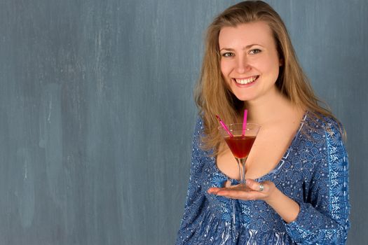 woman with red cocktail glass. Blue wall.