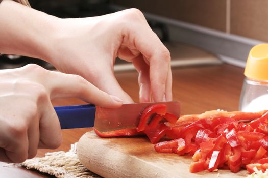 Chopping pepper with knifein small pieces.