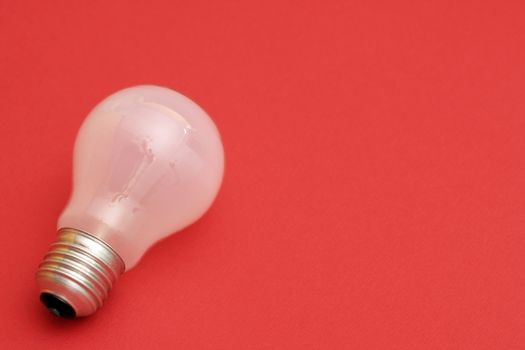 Background with lit lightbulb. Isolated on red