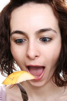 Woman eating tasty pear with forch.