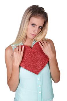Pretty young lady with a sad expression holding a big red heart