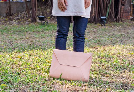 Handbag lying in the grass with girl