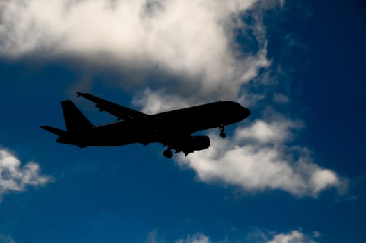 Silhouette of an Airplane Landing over a evening sky