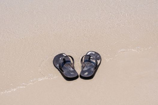 Beach sandals on a sandy beach with background