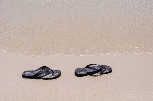 Beach sandals on a sandy beach with background