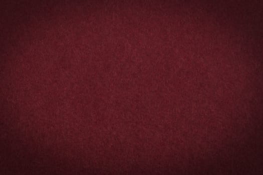 Maroon paper background or texture with vignette