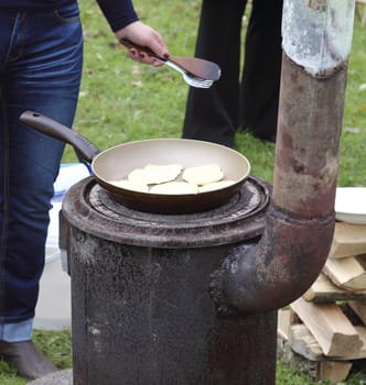 Frying pancakes outdoors on the ancient furnace