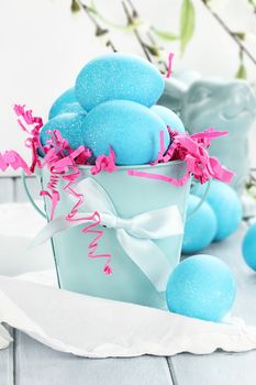 Blue Easter eggs in a blue tin bucket. Shallow depth of field.