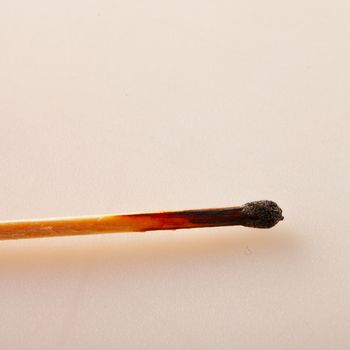 Head of a burnt match over white background, with copyspace