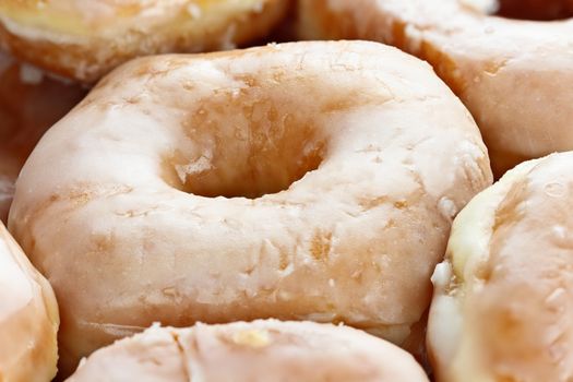 Close up of a box of delicious glazed donuts.