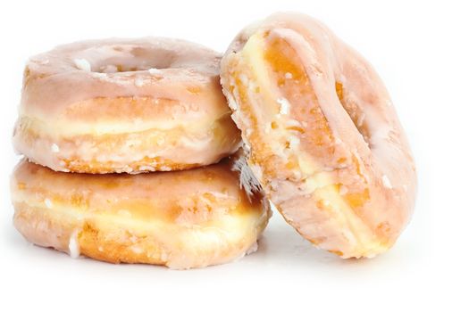 Stacked of glazed donuts isolated over a white background with slight shadow.