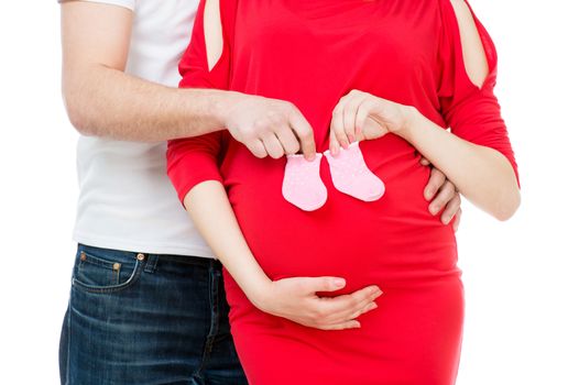 husband hugging his pregnant wife with socks for baby isolated on a white background