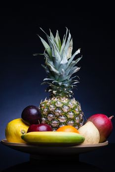 bunch of exotic fruits set up whit pineapple in the middle