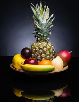 bunch of exotic fruits set up whit pineapple in the middle