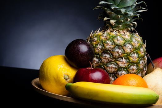 bunch of exotic fruits set up whit pineapple in the middle