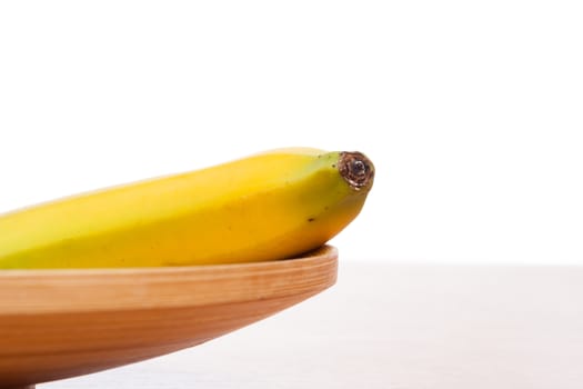 fresh yellow banana on brown wooden plate