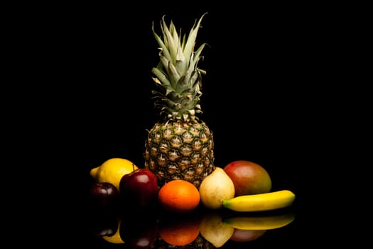 bunch of exotic fruits on black background with reflection