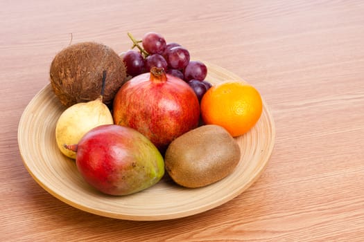 bunch of exotic fruits on a wooden plate