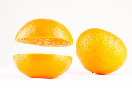 two mandarines one whole one sliced on white background