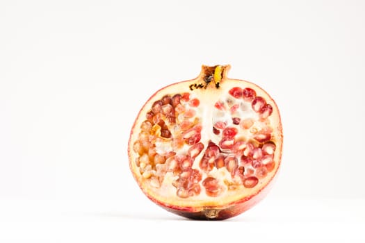 big ripe red sliced pomegranate on white background