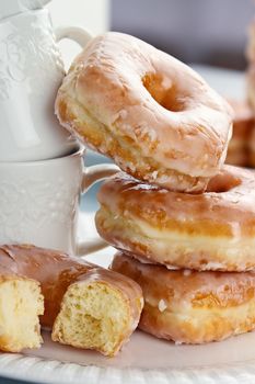 Stacked of delicious glazed donuts with copy space. Shallow depth of field.