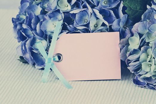 Blank card and flowers over with beautiful hydrangeas and room for your text. Shallow depth of field.