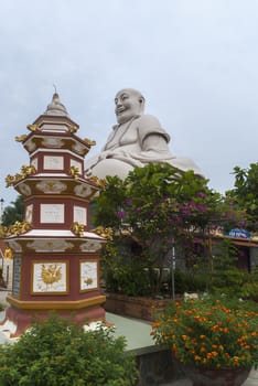 At the Vinh Tranh Pagoda in My Tho, the Mekong Delta, stands this huge statue of the smiling Buddha. Here, the head of the Buddha is seen in combination with a memorial stupa for one of the deceased monks.