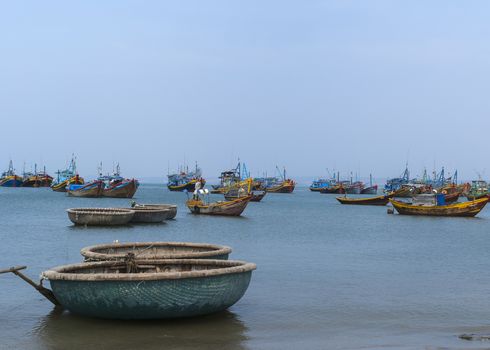 Blue skies and a blue sea floats many fishing vessels and sloops.