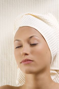 portrait of a young woman resting herself with closed eyes in a spa