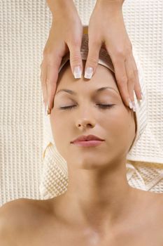 Closeup of human hands doing therapeutic massage on head of cute girl