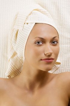 nice portrait of a young woman with bath towels around her head laying