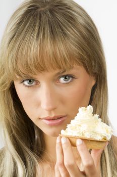 blond nice girl eating a dessert with a lot of cream