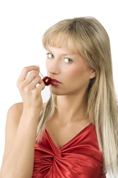 blond sensual girl with red lips and dress keeping a cherry near the lips