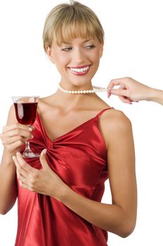 stylish blond girl with pulled pearl necklace from a hand drinking red wine