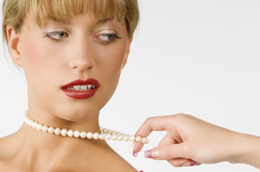 portrait of a cute girl with red lips and pearls necklace pulled by hand