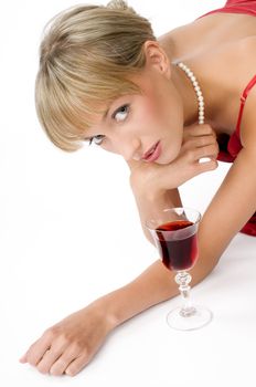 blond girl with necklace laying down on the floor near a glass of red wine