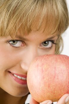 close up on a girl hiding her face behind a red apple
