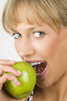 close up of a nice blond woman eating a green apple