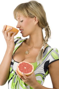 nice and young girl with green dress and braid hair smelling grapefruit
