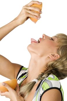 pretty girl with tongue out squeeze and drink juice from a grapefruit
